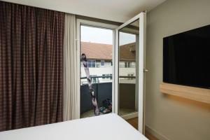 a bedroom with a window with a view of a building at Moxy Annecy in Annecy