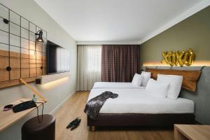 a hotel room with a large bed and a desk at Moxy Annecy in Annecy