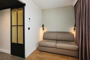 a living room with a couch in the corner at Moxy Annecy in Annecy