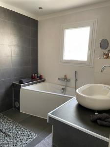 a bathroom with a bath tub and a sink at Zen house with a view in Manosque +16 photos