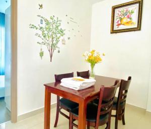 a dining room table and chairs with flowers on the wall at Rose homestay Vinhomes Grand Park 1 bed room in Long Bình