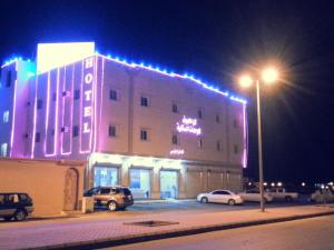 un gran edificio con luces encendidas por la noche en Lara Al Jawf Hotel Apartments, en Sakaka