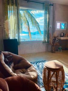 un salon avec une chaise et une grande fenêtre dans l'établissement Khao Khad Beach Bungalow, à Ko Thanan