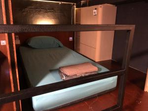 a bunk bed with two towels and a refrigerator at OA ThE FACTORY AT BUKIT BINTANG in Kuala Lumpur