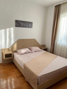 una camera da letto con un letto con testiera in legno di Anika a Trebinje