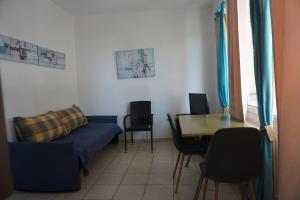 卡拉马塔Sunny Apartments - Tolis 2oς的客厅里有一张沙发、一张桌子和几把椅子 更多7张照片