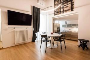 a dining room with a table and chairs and a tv at appartamento palazzo bardi apartments n 2 in Florence