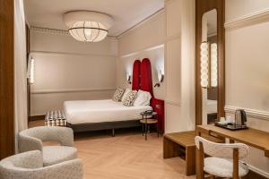 a hotel room with a bed and a desk and chairs at Vincci Soho in Madrid +37 photos