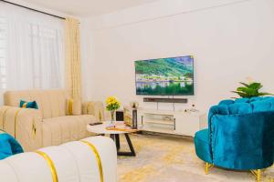 a living room with a couch and a tv at Urban 2 bedroom Nanyuki Mt Kenya Views in Nanyuki