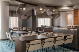 a restaurant with tables and chairs and a bar at SpringHill Suites Detroit Auburn Hills in Auburn Hills