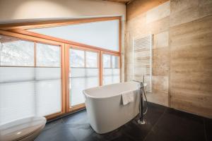 wanna w łazience z oknem w obiekcie IM WEIDACH Superior Chalets w mieście Leutasch +37 zdjęć