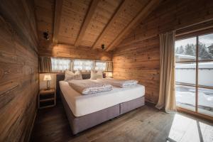 sypialnia z łóżkiem w drewnianym domku w obiekcie IM WEIDACH Superior Chalets w mieście Leutasch