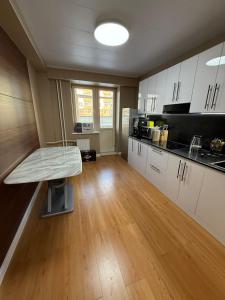a kitchen with white cabinets and a wooden floor at Comfy classic apartment in Central UB in Ulaanbaatar