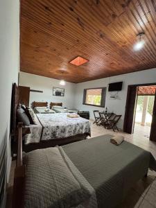 a bedroom with two beds and a wooden ceiling at Pousada Toca da Raposa in Cavalcante