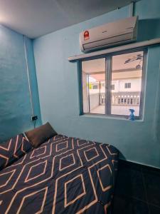 a bedroom with a bed and a window at Sun & Moon Homestay in Port Dickson