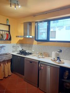 a kitchen with a sink and a stove and a window at la mansarda di Ele in Lucca