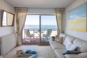 a living room with a couch and a view of the ocean at Au bord de l'eau - Vue imprenable sur le bassin in Arcachon