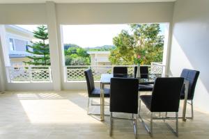 a dining room with a table and chairs and a large window at ไร่ทิพย์โอชาคีรี ฟาร์มสเตย์ ป่าละอู in Ban Pa Lau