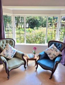 two chairs and a table in a room with a window at Hilton Garden Studio in Hilton