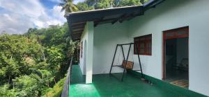 a balcony of a house with a view of the forest at Mandara in Badulla