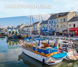 a group of boats docked in a harbor with buildings at La brise marine apt rdc maison cour fermée parking et terrasse à 800 m plage Omaha beach avec table de ping pong proche Port en Bessin in Vierville-sur-Mer