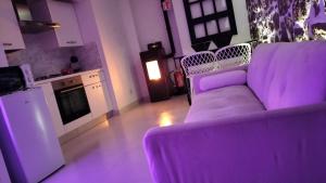 ein Wohnzimmer mit einer lila Couch in einer Küche in der Unterkunft Suite da Ninna 2 in Allai + 16 Fotos