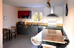 una cucina con un tavolo e un piano di lavoro di Maison Premium Hyper Calme - Joliment décorée avec vue dégagée - Jacuzzi Chauffé - Salle de jeux - Proche de toutes commodités a Montélimar