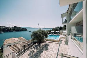a building with a swimming pool next to the water at White House Apartment in Kalami