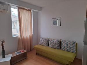 Una sala de estar con un sofá y una ventana. en Aparthotel Salena, en Sunny Beach