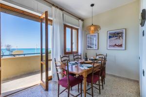 a dining room with a table and chairs and a view of the ocean at Italianway - Rossetti 3 in Marina di Cecina