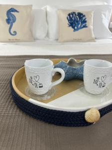 dos tazas de café sentadas en un plato en una mesa en Villa Anna, en Meta