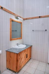ein Badezimmer mit Waschbecken und Spiegel in der Unterkunft orlando cottages in Arusha