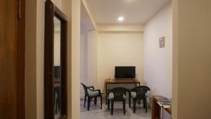 a room with chairs and a table with a television at Kathmandu home in Kathmandu