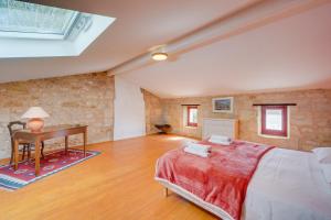 une chambre avec un lit et un bureau dans une pièce dans l'établissement Gîte du Vieux Fourens, entre charme et nature, à Nérigean