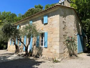 une petite maison en pierre avec un arbre en face de celle-ci dans l'établissement Gîte du Vieux Fourens, entre charme et nature, à Nérigean