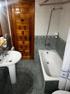 a bathroom with a sink and a tub and a toilet at Hotel Rural El Sestil in Dobres