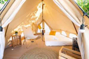 a tent with a bed and a chair in it at Kampaoh Fonts d' Algar in Callosa d'en Sarrià