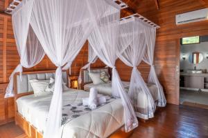 Postel nebo postele na pokoji v ubytování Lumbung River Ubud Villas