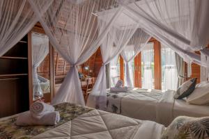 Postel nebo postele na pokoji v ubytování Lumbung River Ubud Villas