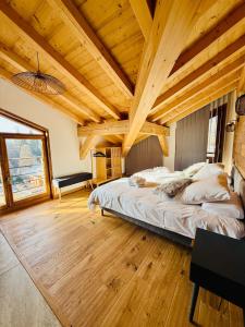 a bedroom with a large bed and wooden ceilings at Chalet Monarch - Les Carroz - Sauna, Spa & vue Montagnes in Arâches-la-Frasse +24 photos