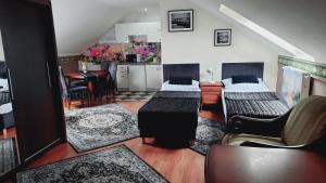 a living room with two beds and a kitchen at Hotel i Apartamenty Rosa in Przemyśl +7 photos