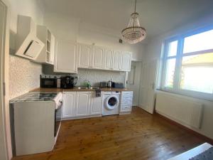 a kitchen with white cabinets and a washing machine at Wrocławska 39 in Środa Śląska