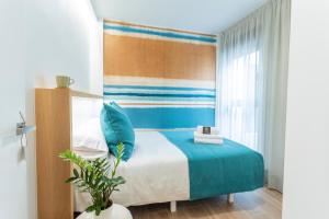 a bedroom with a bed with blue pillows at Eleven Boutique Apartments by Airnest in Las Palmas de Gran Canaria