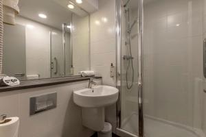 a white bathroom with a sink and a shower at Travelodge Barcelona Poblenou in Barcelona