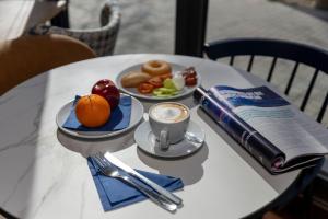 a table with two plates of food and a cup of coffee at Travelodge Barcelona Poblenou in Barcelona