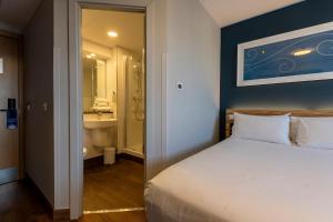 a bedroom with a bed and a bathroom with a sink at Travelodge Barcelona Poblenou in Barcelona