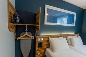 a bedroom with a bed and a blue wall at Travelodge Barcelona Poblenou in Barcelona
