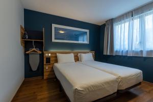a bedroom with a large bed and a blue wall at Travelodge Barcelona Poblenou in Barcelona