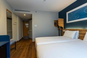 a bedroom with two beds and a blue wall at Travelodge Barcelona Poblenou in Barcelona