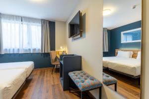 a hotel room with two beds and a table at Travelodge Barcelona Poblenou in Barcelona +87 photos